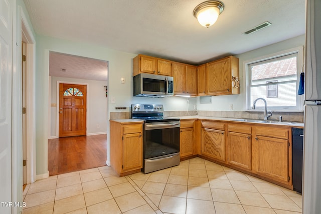 kitchen featuring sink, appliances with stainless steel finishes, and light tile patterned flooring