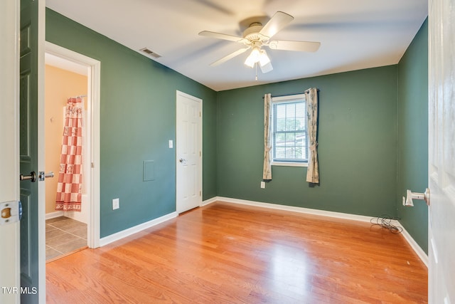 empty room featuring ceiling fan and light hardwood / wood-style flooring