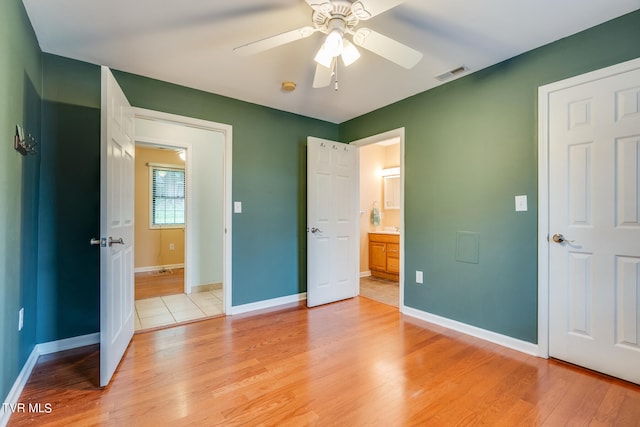 unfurnished bedroom with ceiling fan, light hardwood / wood-style floors, and ensuite bath