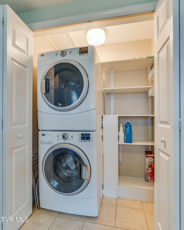 washroom featuring light tile patterned floors and stacked washer and dryer