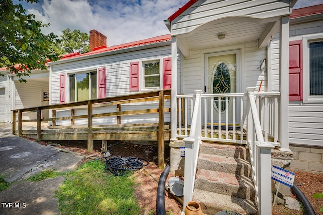 view of exterior entry with a deck