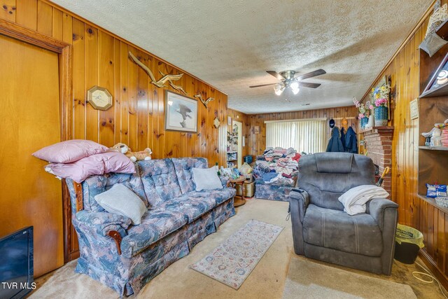 living room featuring carpet flooring, wooden walls, and ceiling fan