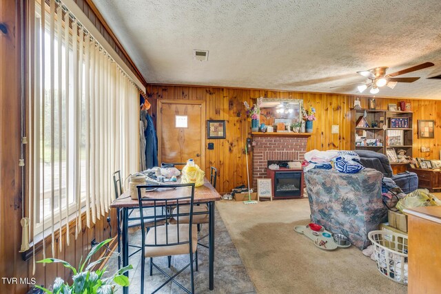 dining area with a wealth of natural light, a brick fireplace, and carpet floors