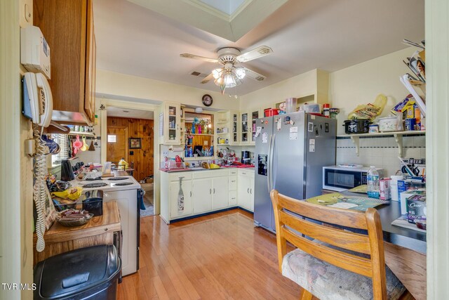 kitchen featuring ceiling fan, appliances with stainless steel finishes, light wood-type flooring, and white cabinets