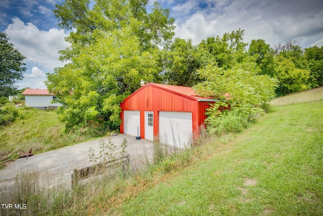 view of outbuilding with a garage and a lawn