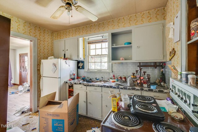 kitchen featuring ceiling fan, white refrigerator, backsplash, and dark tile patterned flooring