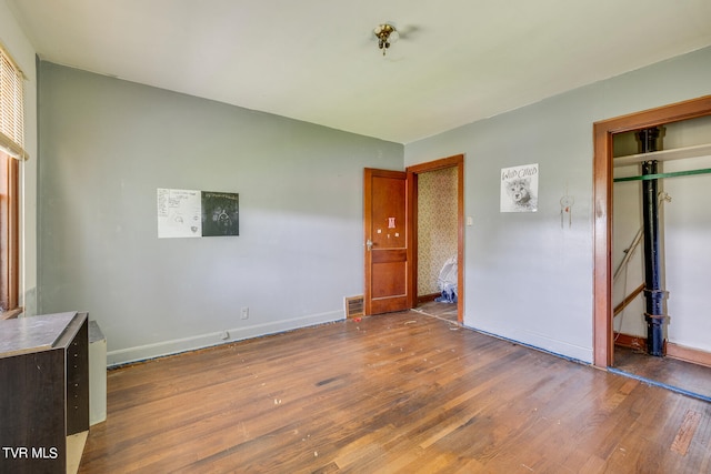 unfurnished bedroom with dark hardwood / wood-style flooring and a closet