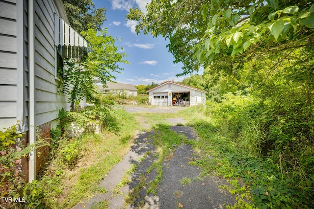 view of yard with a garage and an outbuilding