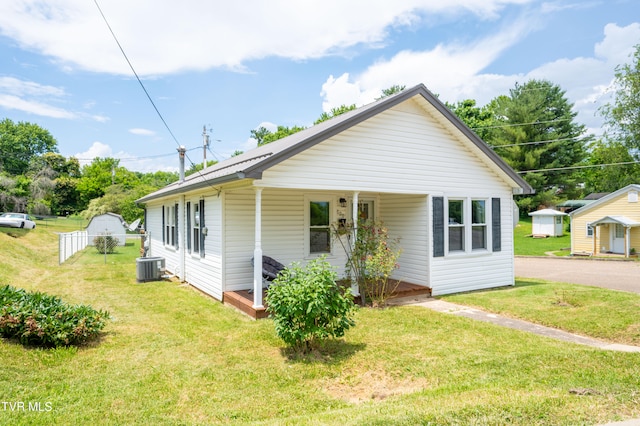 exterior space with a porch, a lawn, and a shed