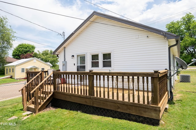 rear view of house with a lawn and a wooden deck