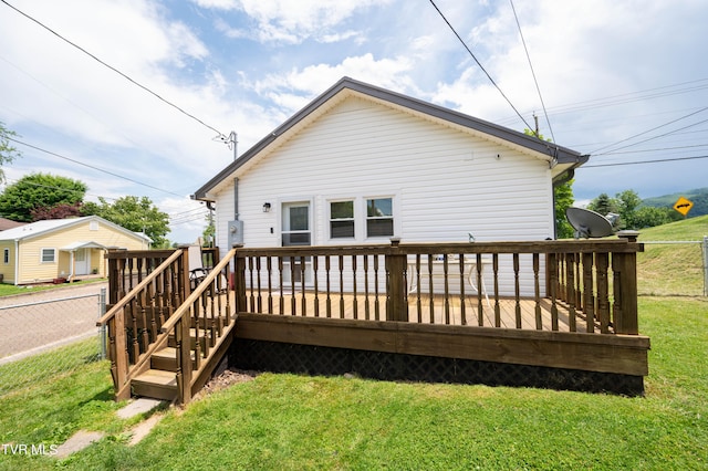 back of property with a yard and a deck