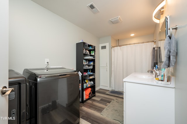 washroom with dark hardwood / wood-style floors, sink, and separate washer and dryer