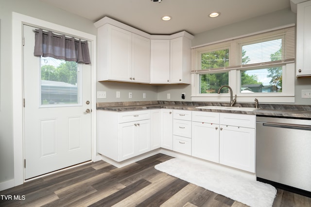 kitchen with dark wood-type flooring, a wealth of natural light, stainless steel dishwasher, and white cabinets