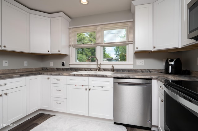 kitchen featuring dark wood-type flooring, stainless steel appliances, sink, and white cabinetry