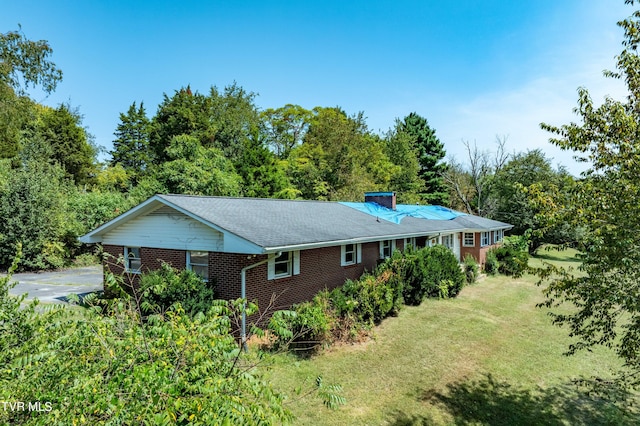 view of front facade with brick siding and a front lawn