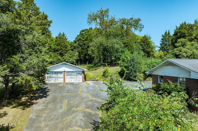 exterior space with brick siding, a detached garage, and an outbuilding