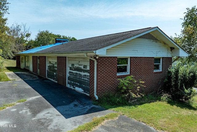 view of side of home featuring a shingled roof and brick siding