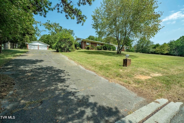 view of front of property with a detached garage, a front lawn, and an outdoor structure