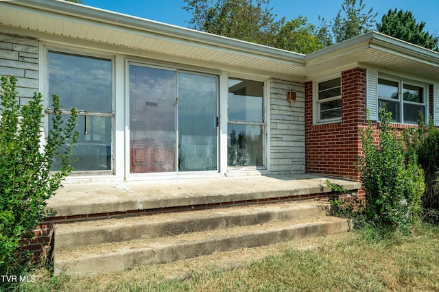 doorway to property with brick siding