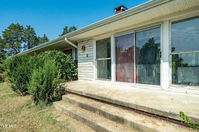 view of exterior entry featuring brick siding