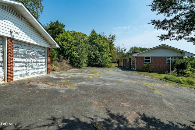 view of property exterior featuring a garage and brick siding