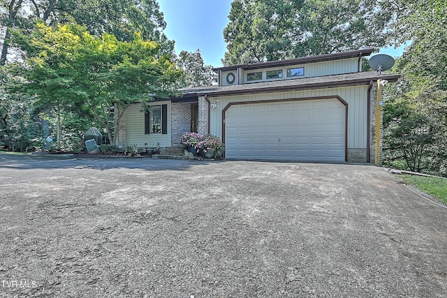 view of front of home with aphalt driveway and a garage