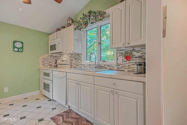 kitchen featuring white cabinetry, white appliances, tasteful backsplash, and a sink