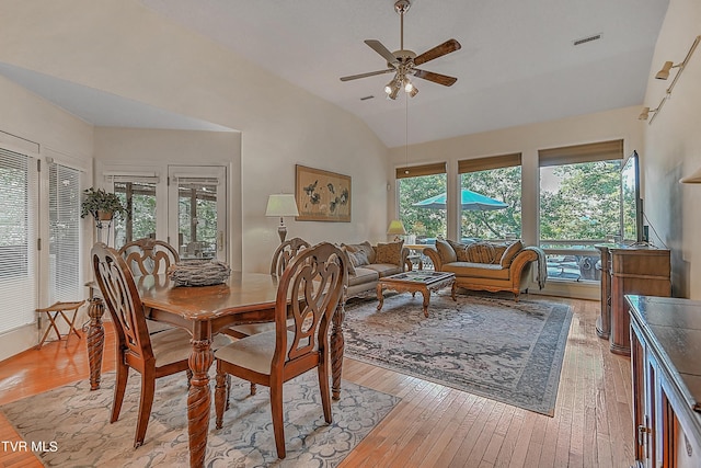 dining room featuring lofted ceiling, light wood-style floors, visible vents, and ceiling fan