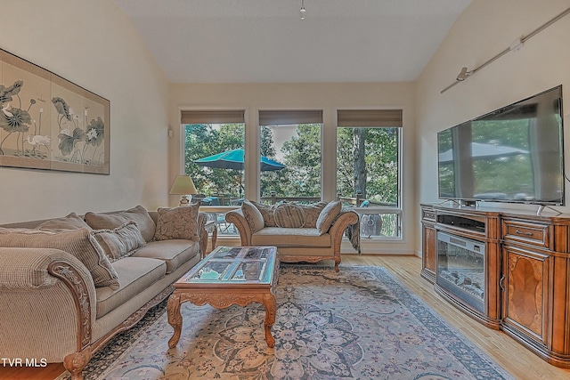 living room with light wood-type flooring and vaulted ceiling