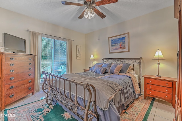 bedroom with a textured ceiling, light tile patterned flooring, and a ceiling fan