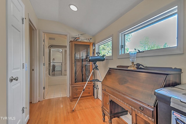 misc room featuring light wood-type flooring, visible vents, and vaulted ceiling