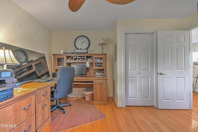 office space with a textured ceiling, light wood-style flooring, and a ceiling fan