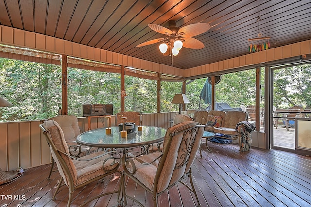 sunroom / solarium with wood ceiling and a ceiling fan