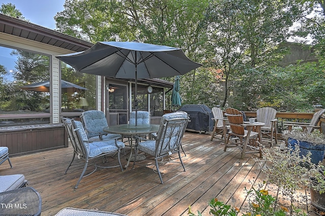 wooden deck with grilling area and outdoor dining space