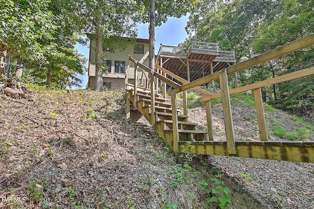 view of property exterior featuring a deck and stairs