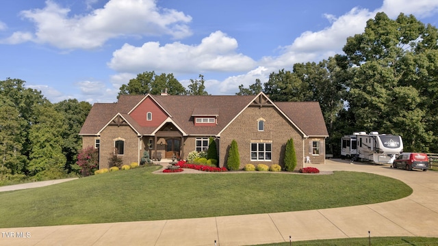 view of front of property with brick siding, a chimney, and a front yard