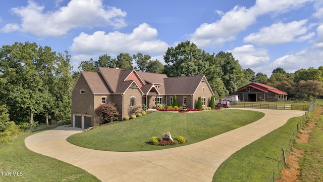 view of front of home with a front yard, concrete driveway, fence, and a garage