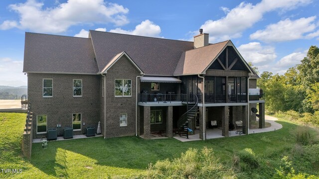 back of property featuring a lawn, a patio, and central AC