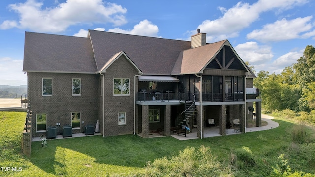 rear view of property featuring a yard, stairway, central AC unit, a chimney, and a patio area