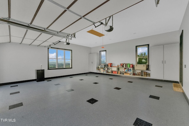 garage featuring visible vents, a garage door opener, and baseboards