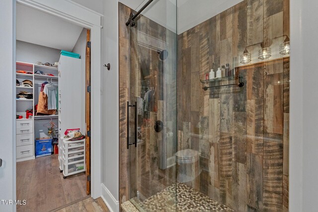 bathroom with hardwood / wood-style floors and a shower with door