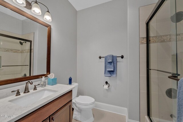 bathroom with vanity, toilet, and an enclosed shower