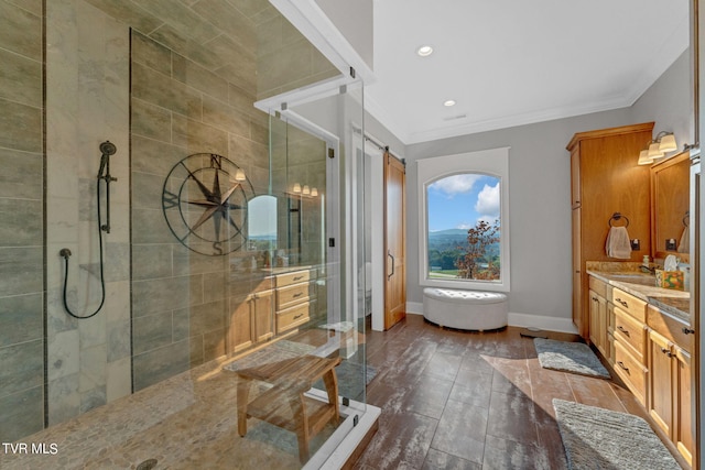 bathroom with vanity, wood finished floors, baseboards, tiled shower, and crown molding