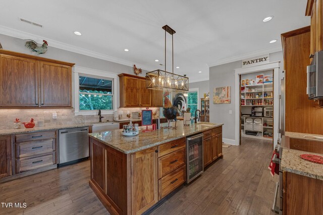 kitchen with dark hardwood / wood-style flooring, appliances with stainless steel finishes, an island with sink, and wine cooler