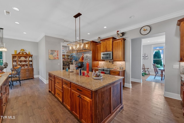 kitchen with brown cabinetry, appliances with stainless steel finishes, dark wood-style floors, and crown molding