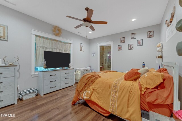 bedroom featuring connected bathroom, ceiling fan, and light hardwood / wood-style floors