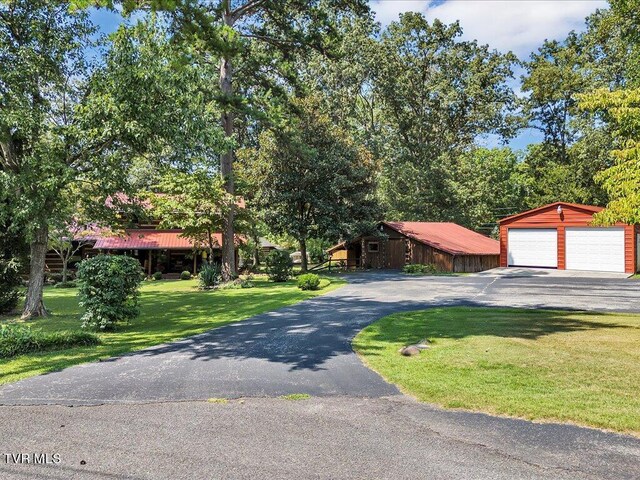 view of front of property featuring an outbuilding, a garage, and a front lawn