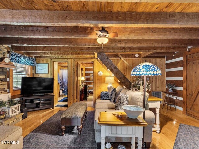 living room featuring wood walls, wood-type flooring, and ceiling fan