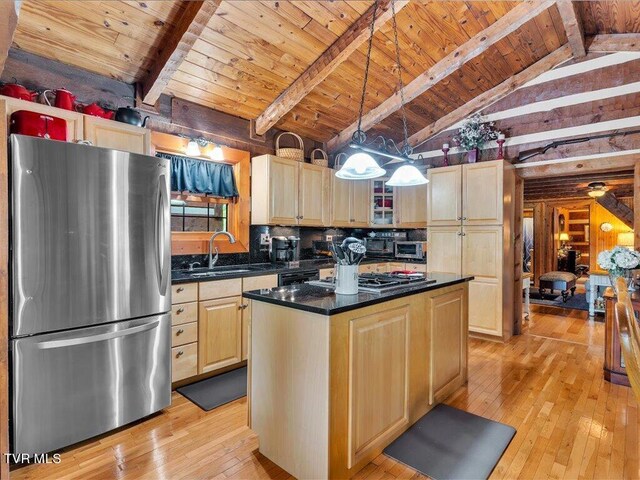 kitchen featuring lofted ceiling with beams, a center island, stainless steel refrigerator, and light hardwood / wood-style floors