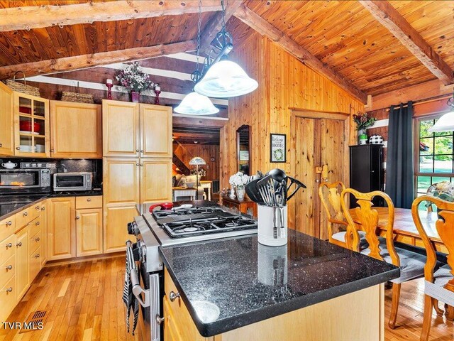 kitchen with wood walls, high end stainless steel range, a center island, lofted ceiling with beams, and light wood-type flooring